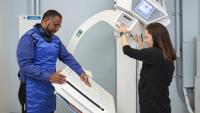 Xray tech prepares xray machine for male patient's hand